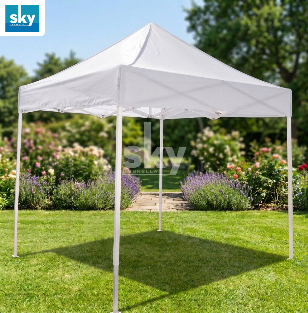 A white pop-up canopy tent set up on a green lawn in a garden, with trees and flower beds in the background. Waterproof and UV Resistant