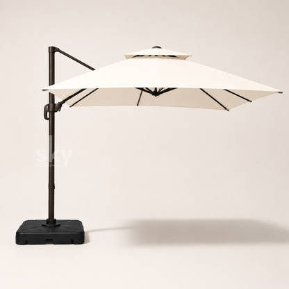 A double top deluxe square patio umbrella with an off white canopy and a black metal frame and base, shown against a neutral light beige background.