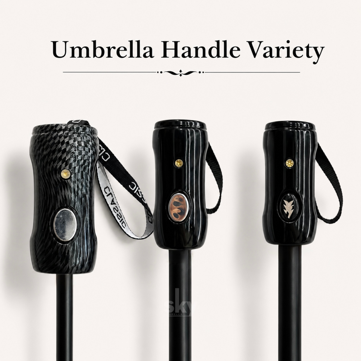 Three black umbrella handles displayed side by side under the text 'Umbrella Handle Variety' on a light beige background. The left handle has a dark woven carbon-fiber pattern with a silver oval button and a black-and-white branded wrist strap.