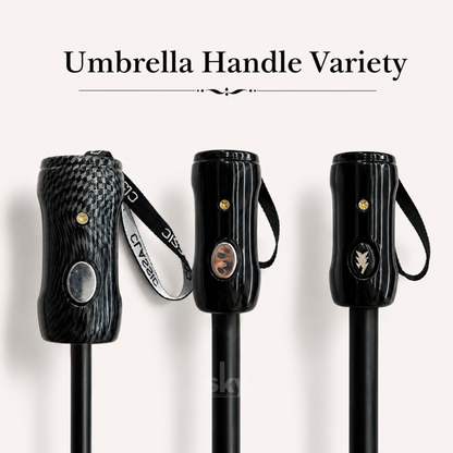 Three black umbrella handles displayed side by side under the text 'Umbrella Handle Variety' on a light beige background. The left handle has a dark woven carbon-fiber pattern with a silver oval button and a black-and-white branded wrist strap.