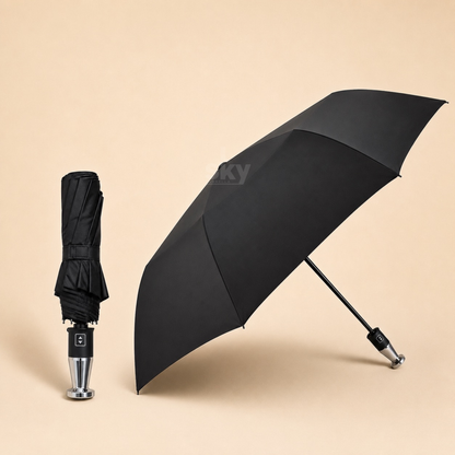 A black folding umbrella shown open and closed on a warm beige studio background. The open umbrella is angled to the right, and the closed umbrella stands upright on the left.