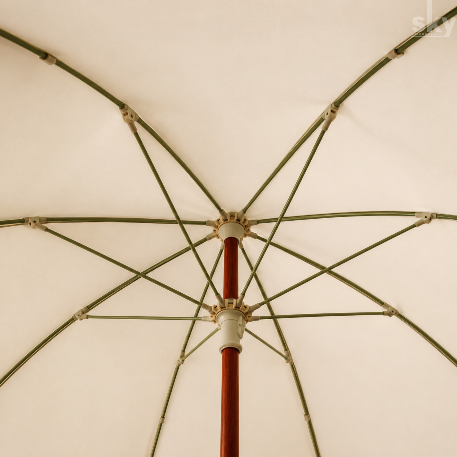 Close-up internal view of an umbrella canopy and internal support structure, showing a cream fabric top, green metal ribs, and a reddish-brown central pole.