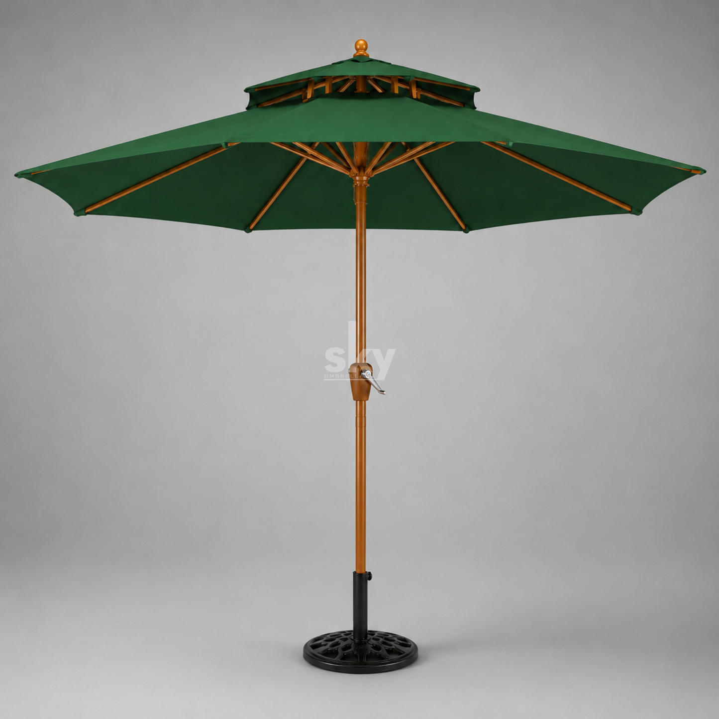 A green patio umbrella with a wooden pole finish and black metal base, shown against a neutral gray background.