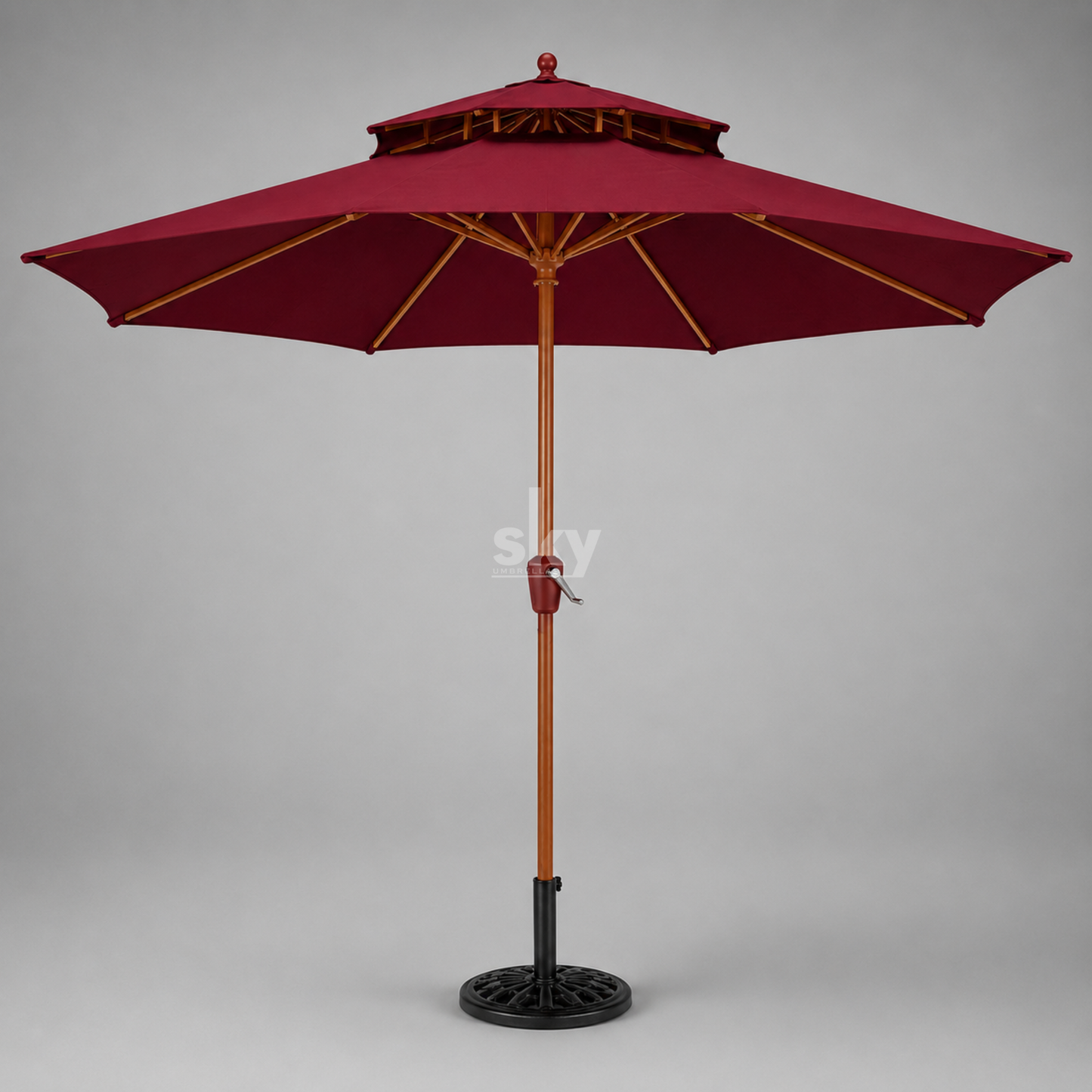 A double-tiered patio umbrella with a maroon canopy, brown wooden pole finish, and black metal base on a neutral gray background.