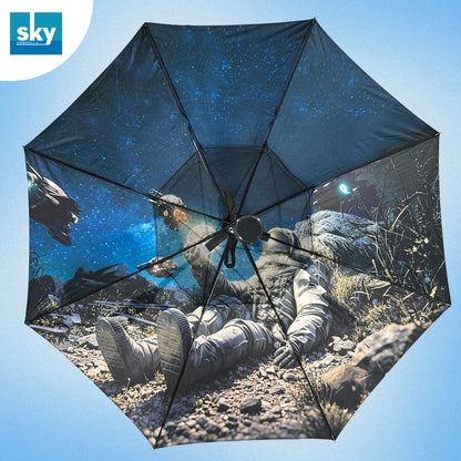 A large open umbrella with a printed space-themed design showing astronauts on a rocky surface under a starry blue sky. The umbrella is centered against a light blue gradient background, and a blue 'sky' logo appears in the top-left corner.