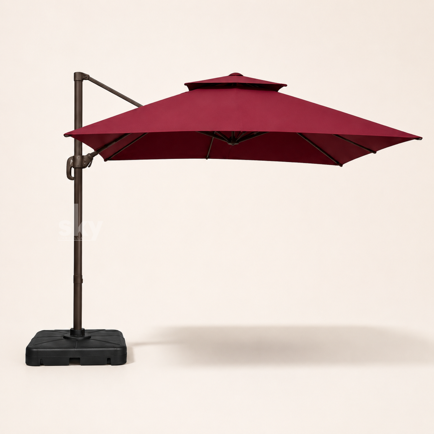 A Maroon double top Deluxe Square patio umbrella with a black metal pole and base, shown against a plain off-white background. 