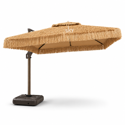 A square offset patio umbrella with a natural straw-colored thatched roof and a dark brown metal pole on a black weighted base, shown against a plain white background.